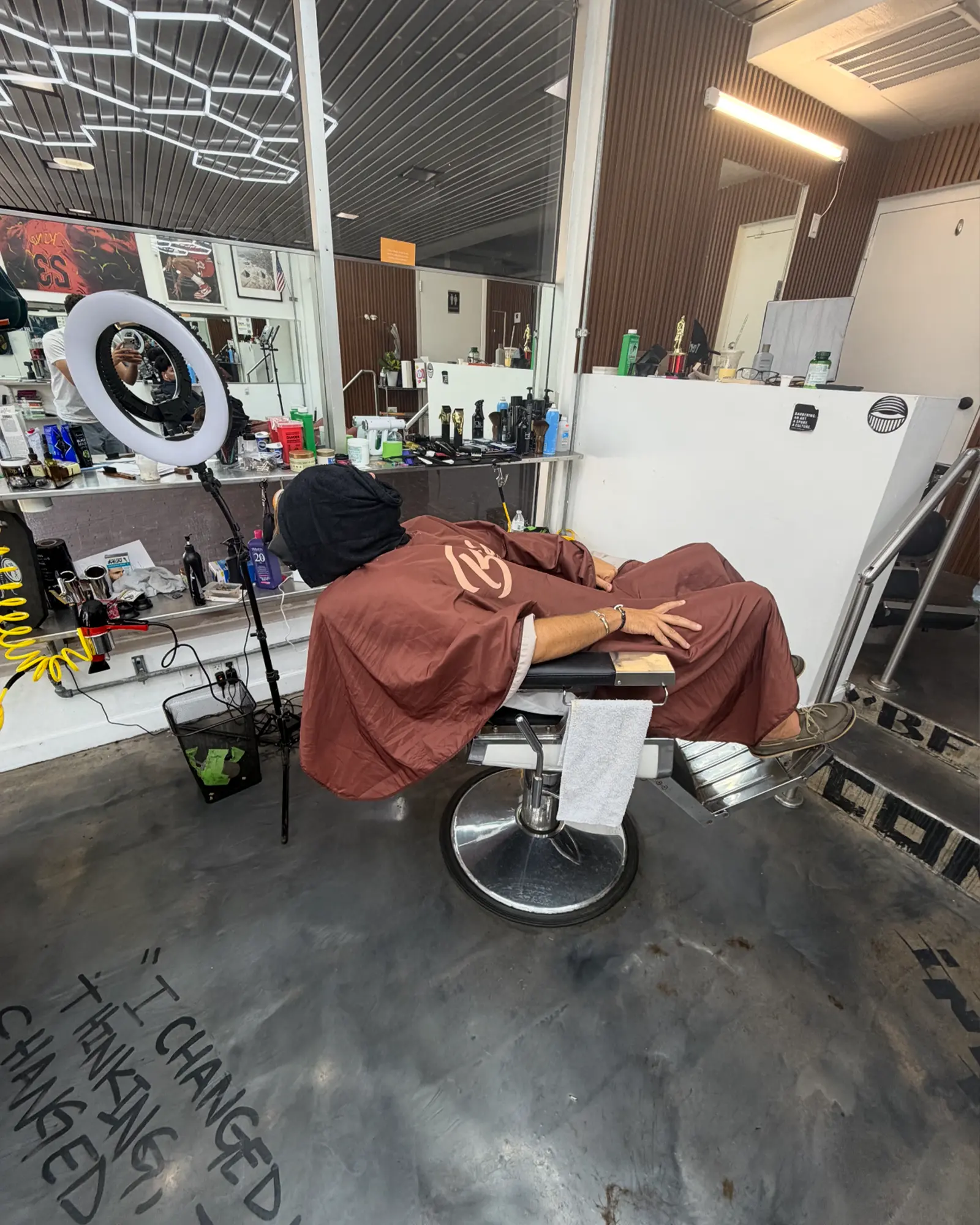 Client reclined mid-service in the barber chair at Alchemy Hair Lab in Coral Gables