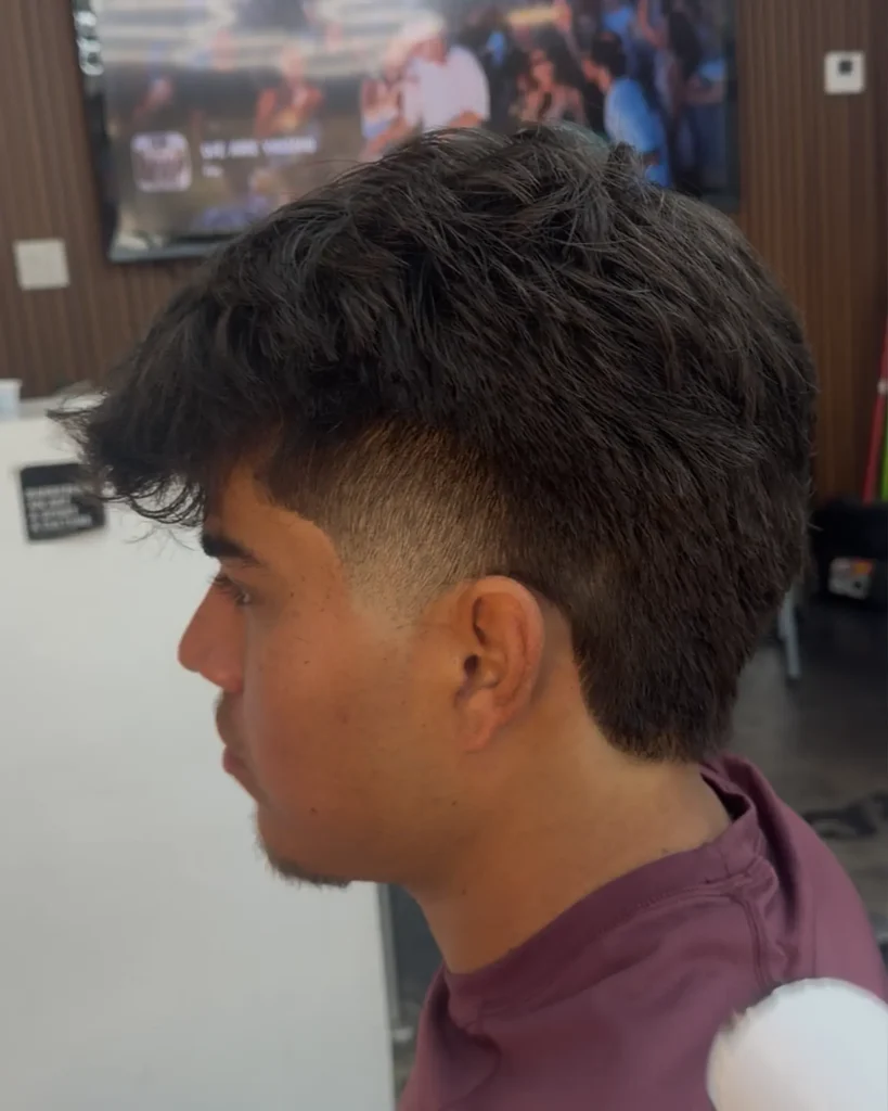 Textured crop with a shaved hard part and taper fade by Leo Sanchez