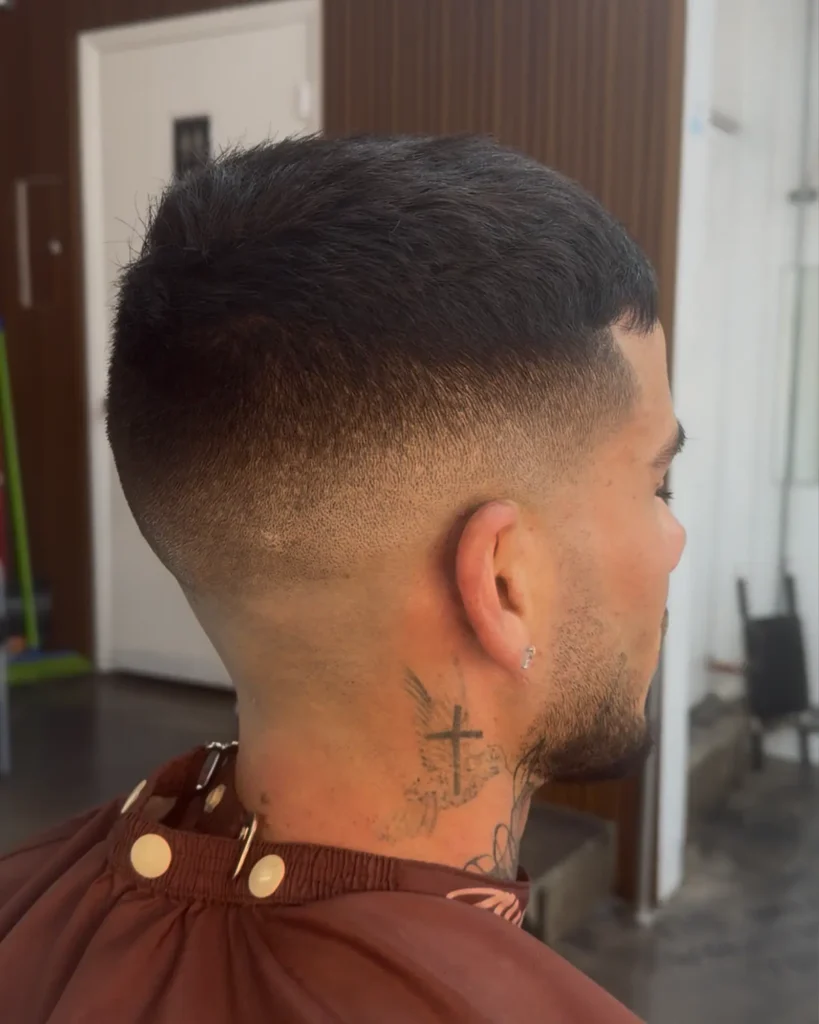 Back view of a skin fade blended from bare skin into dark hair, cut by Leo Sanchez