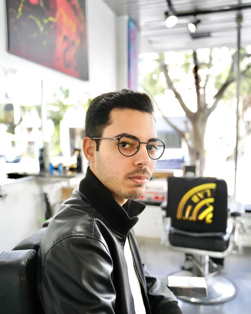 Client in the chair at Alchemy Hair Lab after a classic side part cut