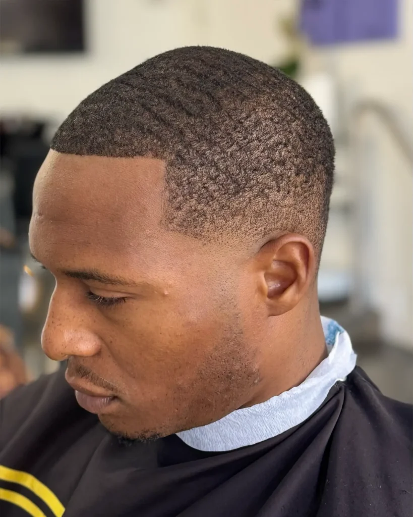 Razor-sharp hairline edge-up on natural waves, cut by Luis Mosquera