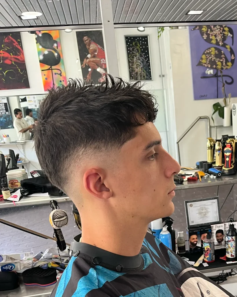 Spiky textured top above a mid skin fade, cut by Luis Mosquera