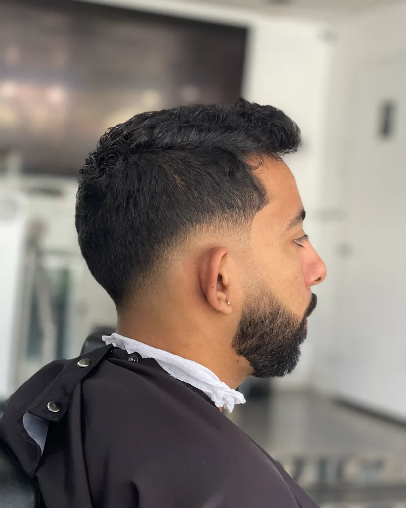Low taper fade paired with a full connected beard, cut by Luis Mosquera